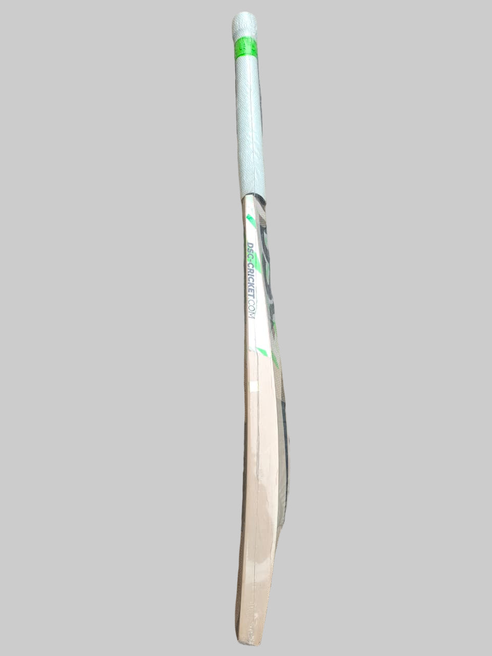 Wooden cricket bat on a hexagonal tiled floor