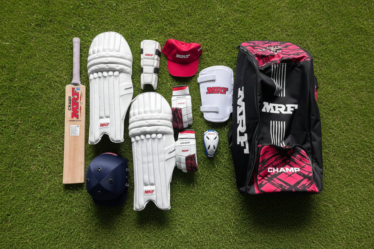 Collection of cricket equipment including a bat, helmet, pads, and bag on a wooden surface with MRF branding.